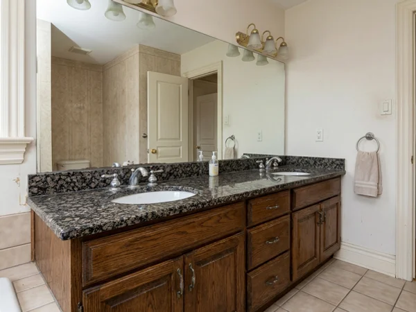 Before: dated granite double vanity in a Rosedale master bath
